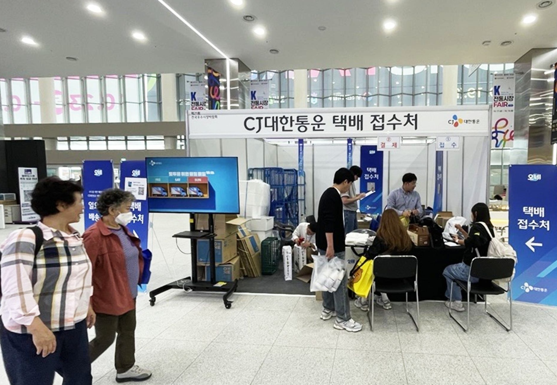 지난해 충청북도 청주 오스코에서 열린 ‘2025 K-전통시장페어 in 청주(전국 우수시장 박람회)’에서 방문객들이 CJ대한통운 택배 접수처를 이용하고 있다.